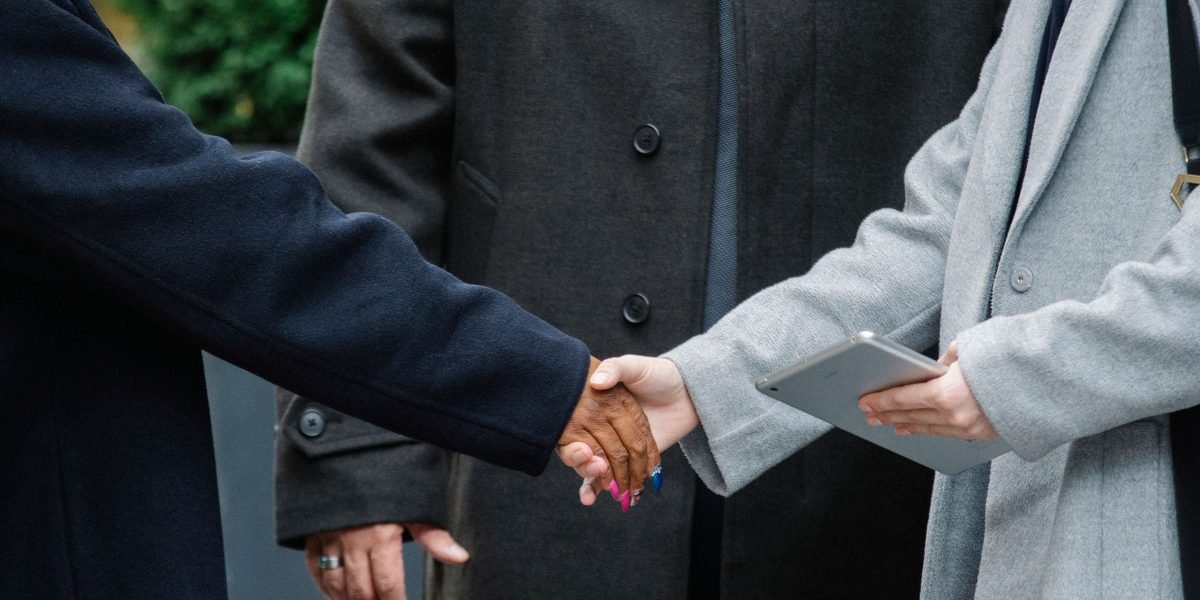 Professionals concluding a successful meeting with a handshake, signifying a new partnership.
