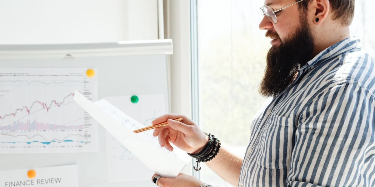 A person focused on analyzing business data and charts, symbolizing AI-driven insights.