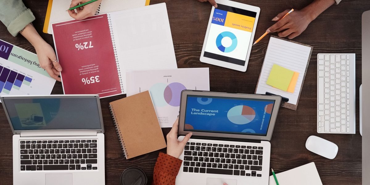 A diverse team actively collaborating around a whiteboard, planning a multi-platform digital marketing strategy.
