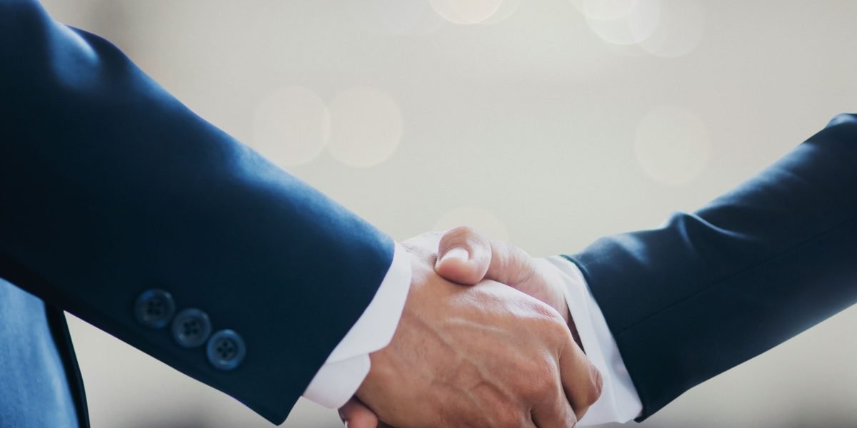 Professionals shaking hands after a productive meeting, representing a confident partnership decision.