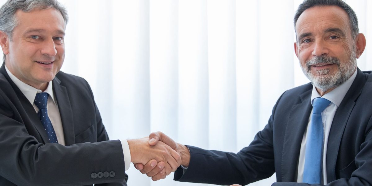 Business partners solidifying their agreement with a handshake, ready for the next steps.