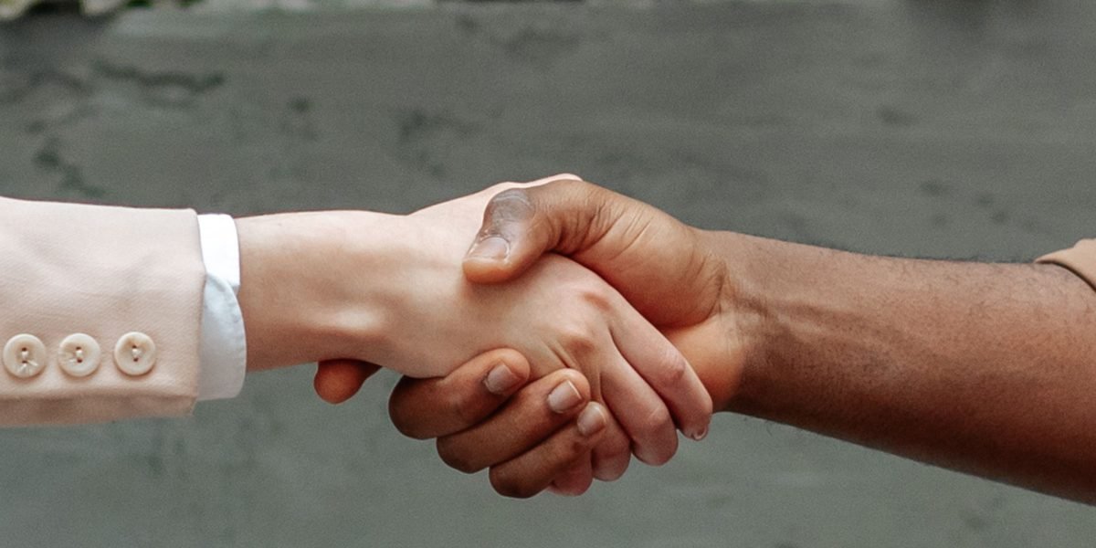 Two professionals shake hands, finalizing an agreement for website development and ongoing maintenance, ensuring clear pricing and reliable support.