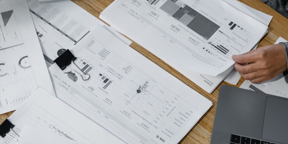 A small business owner strategizing marketing campaigns with printed materials.