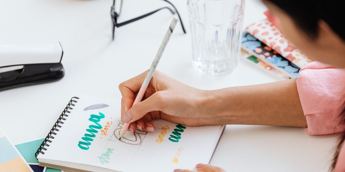 A creative professional sketching design ideas in a notebook, symbolizing the custom approach of advanced design tools.