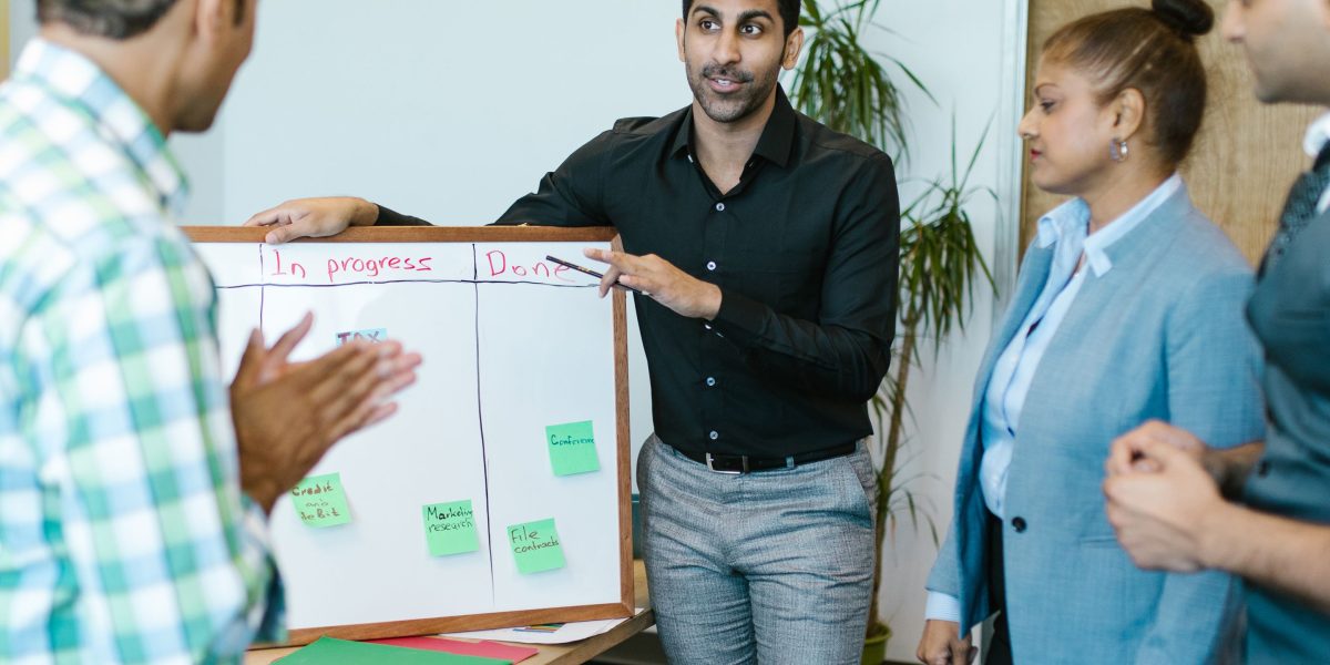A small business team actively discusses long-term marketing strategies in a bright office.