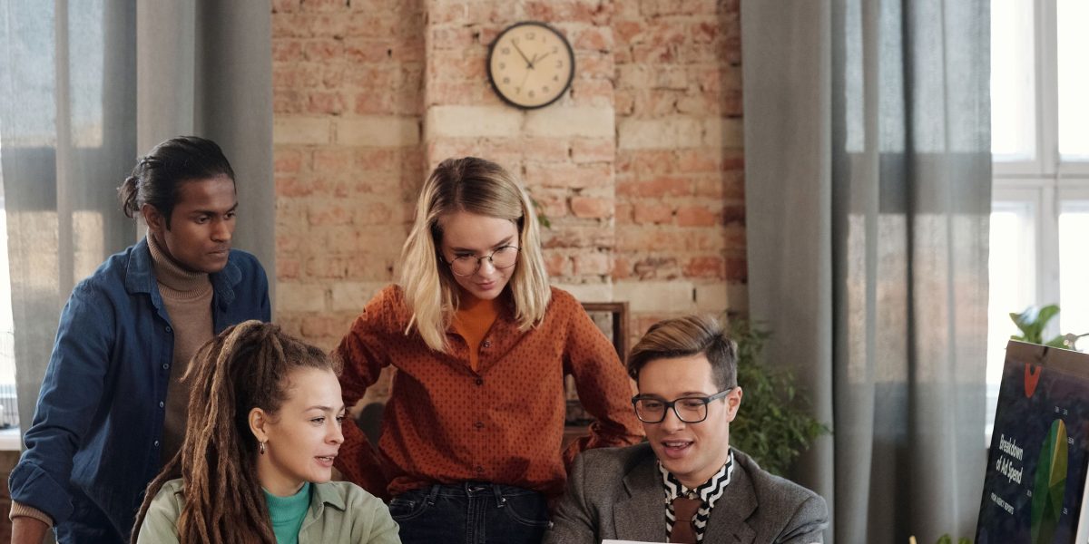 A diverse team of professionals actively discussing ideas around a table, collaborating on a strategy. A team collaborates, brainstorming target audiences and effective placements for their digital ads.