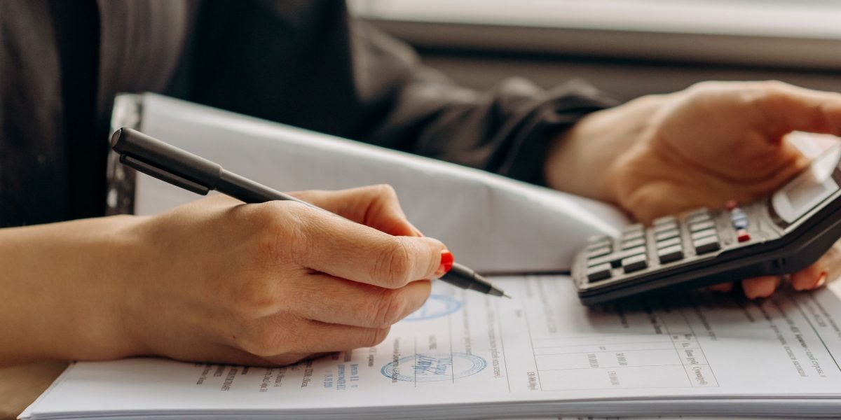 A person looking at a document with graphs, focusing intently, representing budget review. A business professional carefully reviews financial reports to optimize advertising spend.