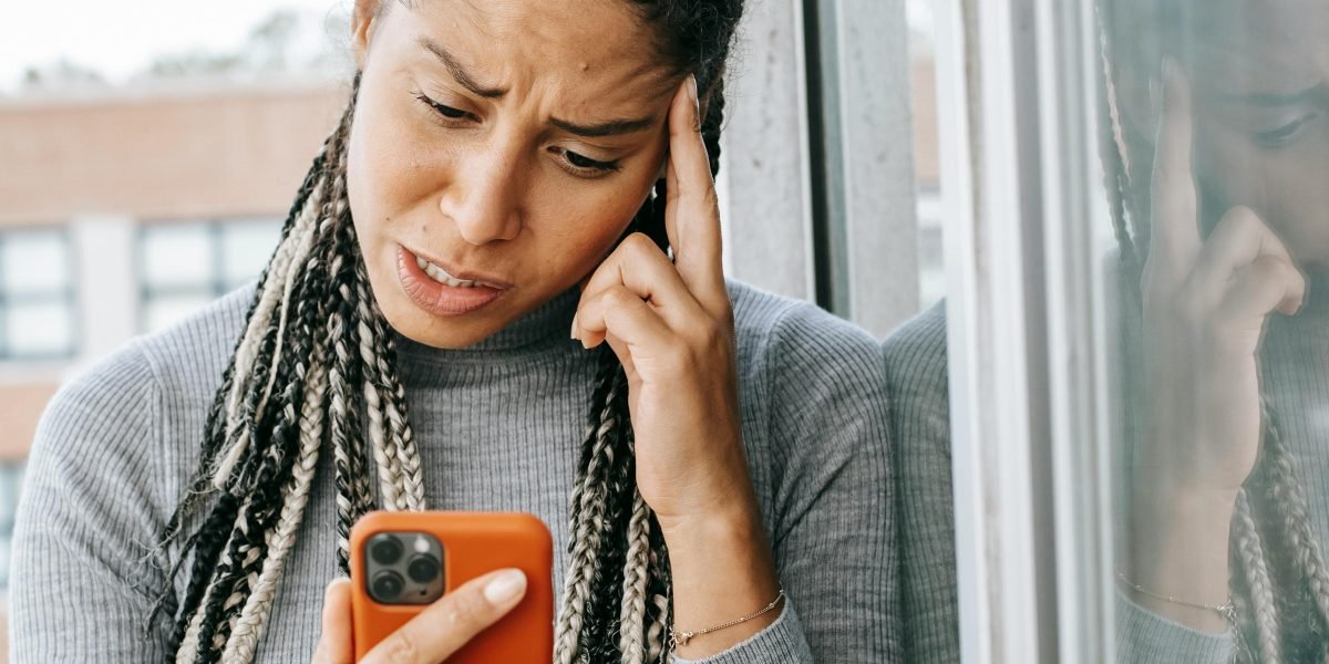 A person looking frustrated while browsing on a device, reflecting the experience of a 'bored' website.