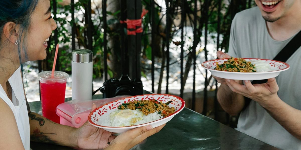 Customers comfortably reviewing a well-designed restaurant menu, indicating a positive user experience facilitated by graphic design.