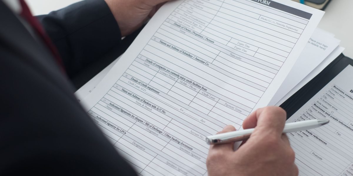 A young person intently reviewing documents or an online application form, symbolizing the careful consideration of eligibility criteria.